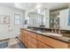 Bathroom with dual sinks, granite countertops, a large mirror, and glass shower at 1744 S Leyden St, Denver, CO 80224