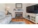 Living room with a brick fireplace, mantle with decorations, and large window at 1744 S Leyden St, Denver, CO 80224