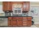 Kitchen featuring wood cabinets, stainless steel appliances, tile backsplash, and black countertops at 1744 S Leyden St, Denver, CO 80224