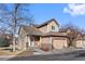 Tan two-story home with attached garage and landscaping at 6817 S Webster St # C, Littleton, CO 80128