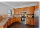 Modern kitchen with stainless steel appliances and wood cabinets at 6817 S Webster St # C, Littleton, CO 80128