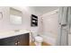 Bathroom featuring a dark vanity, toilet, shower-tub combo, and a decorative shelf above the toilet at 3071 S Truckee St, Aurora, CO 80013