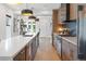 Bright, modern kitchen features an island, white countertops, stainless steel appliances, and wood cabinets at 2702 Lowell Blvd, Denver, CO 80211