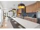 Bright kitchen featuring an island with white countertop, wooden cabinets, and modern pendant lighting at 2702 Lowell Blvd, Denver, CO 80211