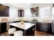 Modern kitchen featuring granite countertops, dark cabinets, stainless steel appliances, and an island at 8953 E Northfield Blvd, Denver, CO 80238