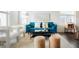 Stylishly furnished living room with a plush blue sofa, white chairs, and a modern coffee table at 8953 E Northfield Blvd, Denver, CO 80238