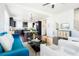 Open concept living room and kitchen area with dark wood floors and a teal blue sofa at 8953 E Northfield Blvd, Denver, CO 80238