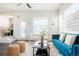 Bright living room featuring a blue sofa, modern decor, large windows, and a ceiling fan at 8953 E Northfield Blvd, Denver, CO 80238
