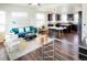 Open concept living room and kitchen area with dark wood floors and a teal blue sofa at 8953 E Northfield Blvd, Denver, CO 80238