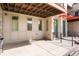 Inviting ground-level patio with a blue door, overhead shade, and ample space for outdoor relaxation at 8953 E Northfield Blvd, Denver, CO 80238