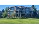 Luxury home exterior with large windows, balconies, and manicured lawn at 2421 Ranch Reserve Rdg, Denver, CO 80234