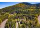 Scenic aerial view of a home nestled among colorful trees, with a mountain backdrop at 32252 Steven Way, Conifer, CO 80433