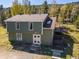 Aerial view of a two-story home with a deck surrounded by a lush forest landscape at 32252 Steven Way, Conifer, CO 80433
