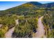 Aerial view showing treelined roads and surrounding landscape, emphasizing the property's serene and private location at 32252 Steven Way, Conifer, CO 80433