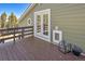 Wooden back deck with an additional pet access point and french doors to home's interior at 32252 Steven Way, Conifer, CO 80433