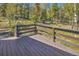 Spacious wooden deck with brown railings and beautiful views of the surrounding landscape at 32252 Steven Way, Conifer, CO 80433
