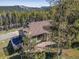 A cozy mountain home nestled among lush trees features a spacious deck for enjoying serene outdoor living at 32252 Steven Way, Conifer, CO 80433