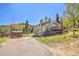Exterior elevation of the home highlighting its architectural details, wooden shed and outdoor features at 32252 Steven Way, Conifer, CO 80433