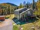 Charming two-story home featuring a deck, lush landscaping, and scenic mountain views at 32252 Steven Way, Conifer, CO 80433