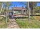 Charming home with green siding, a brown roof, and surrounded by tall trees at 32252 Steven Way, Conifer, CO 80433