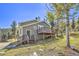 Exterior view of a lovely home featuring a wood deck and a well-maintained lawn at 32252 Steven Way, Conifer, CO 80433
