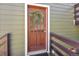 Front door of the house with a wreath hanging on it and wood paneling surrounding at 32252 Steven Way, Conifer, CO 80433