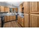 Well-lit kitchen featuring wood cabinets, stone countertops, stainless steel appliances, and wood floors at 32252 Steven Way, Conifer, CO 80433