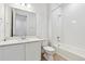 Modern bathroom with white cabinets, and a shower-tub combo with white tile at 9712 Cathay St, Commerce City, CO 80022