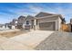 Attractive home featuring stone accents and a large concrete driveway at 9712 Cathay St, Commerce City, CO 80022