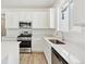 Modern kitchen with white cabinets, stainless steel appliances, and ample counter space at 9712 Cathay St, Commerce City, CO 80022
