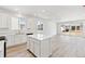 Bright kitchen features white cabinets, an island, and a sliding glass door at 9712 Cathay St, Commerce City, CO 80022