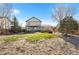 Large yard featuring a covered patio, green grass, landscaping and mature trees at 2331 Ance St, Strasburg, CO 80136