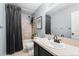 Well-lit bathroom featuring a shower-tub combination with stylish gray tiling, a sink vanity, and modern fixtures at 2331 Ance St, Strasburg, CO 80136