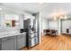 Open-concept kitchen and dining area with stainless steel appliances and hardwood floors at 2331 Ance St, Strasburg, CO 80136