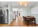 Bright dining area adjacent to the kitchen, featuring hardwood floors and a modern lighting fixture at 2331 Ance St, Strasburg, CO 80136