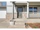 Charming front porch with brick accents, features a decorative door and potted plant, inviting curb appeal at 2331 Ance St, Strasburg, CO 80136