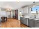 Well-lit kitchen and dining space featuring hardwood floors, stainless steel appliances, and modern cabinetry at 2331 Ance St, Strasburg, CO 80136