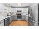 Spacious kitchen with stainless steel appliances, gray cabinets, and hardwood floors at 2331 Ance St, Strasburg, CO 80136