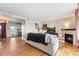 Open living room with a fireplace and hardwood floors that flows into the kitchen at 2331 Ance St, Strasburg, CO 80136