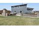 Beautiful backyard featuring a stone fireplace, seating area, and well-maintained lawn at 795 Woodmoor Acres Dr, Monument, CO 80132