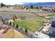 A spacious fenced backyard with a playset, trampoline, lush green lawn and a stone patio at 795 Woodmoor Acres Dr, Monument, CO 80132