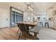 Bright dining room features a rustic wood table with a mud room locker system and views into the white kitchen at 795 Woodmoor Acres Dr, Monument, CO 80132