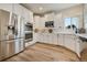 Bright kitchen features stainless steel appliances, double ovens, white cabinets and light wood flooring at 795 Woodmoor Acres Dr, Monument, CO 80132