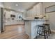 Modern white kitchen with stainless steel appliances, a breakfast bar, and ample counter space at 795 Woodmoor Acres Dr, Monument, CO 80132