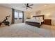 Spacious primary bedroom has a ceiling fan, Peloton bike, and a large window for natural light at 795 Woodmoor Acres Dr, Monument, CO 80132