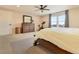 Comfortable primary bedroom features plush carpet, ceiling fan, large windows and ample natural light at 795 Woodmoor Acres Dr, Monument, CO 80132