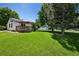 Expansive backyard with lush lawn, wooden deck, and mature trees, ideal for outdoor enjoyment at 9747 W Peakview Dr, Littleton, CO 80123