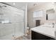 Beautifully remodeled bathroom with glass-enclosed shower, white marble-style tile, and gray vanity at 9747 W Peakview Dr, Littleton, CO 80123