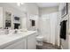 Well-lit bathroom featuring a shower over bath, white cabinets and modern fixtures at 9747 W Peakview Dr, Littleton, CO 80123
