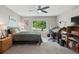 Bright bedroom featuring neutral walls, carpet, ceiling fan, and desk area with view of backyard at 9747 W Peakview Dr, Littleton, CO 80123